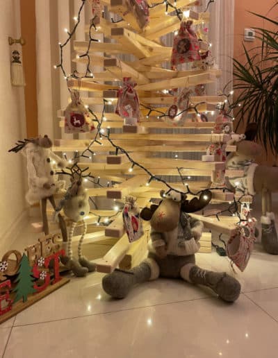 Geschmückter Holzweihnachtsbaum aus Fichtenholz mit Lichterkette als Adventskalender