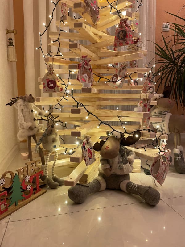 Geschmückter Holzweihnachtsbaum aus Fichtenholz mit Lichterkette als Adventskalender