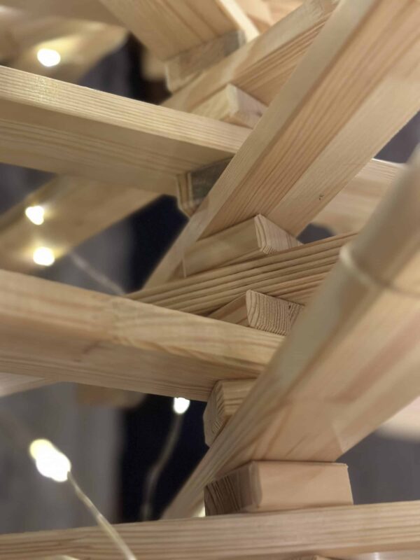 Detailaufnahme eines Franky Tree Holzweihnachtsbaumes aus Kiefernholz, die zeigt, wie die Latten mit Zwischenstücken zusammengesetzt sind, um Stabilität und Flexibilität zu gewährleisten.