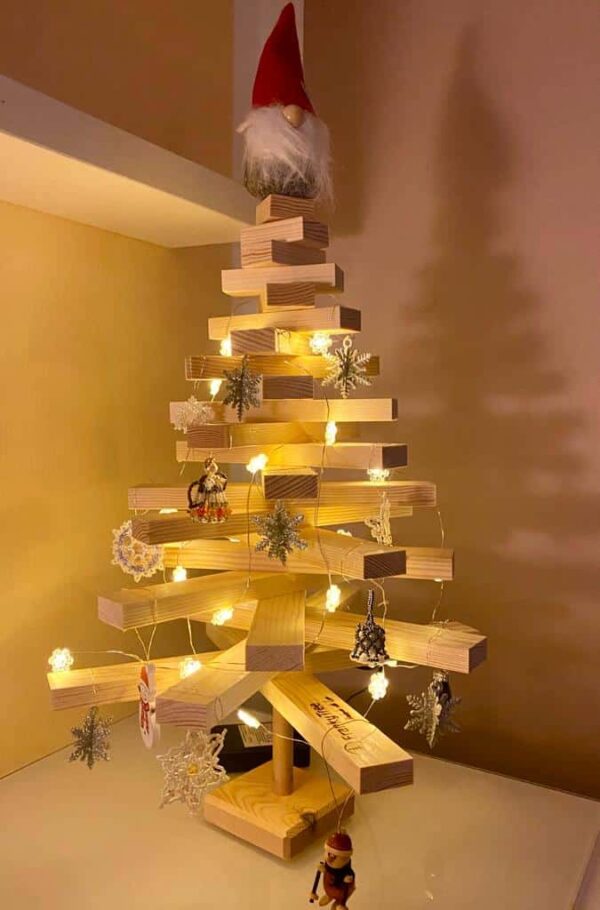 Tiny Franky Holzweihnachtsbaum mit einer Höhe von 40 cm, dekoriert mit Lichterkette und kleinen Anhängern, ideal für kleine Räume oder als Tischdekoration.