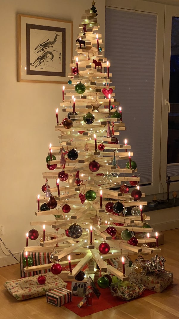 Geschmückter Holzweihnachtsbaum aus Fichtenholz mit Lichterkette als Adventskalender