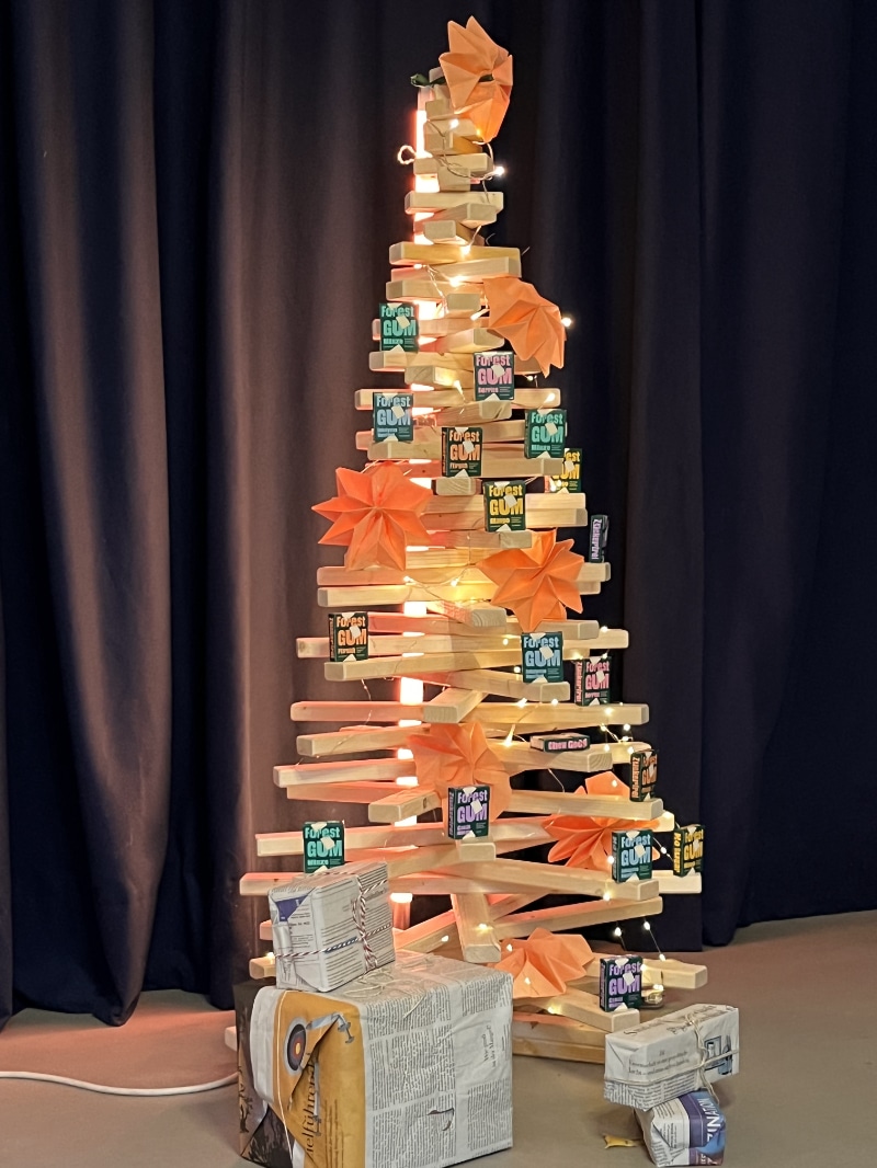 Geschmückter Holzweihnachtsbaum aus Fichtenholz mit Lichterkette als Adventskalender